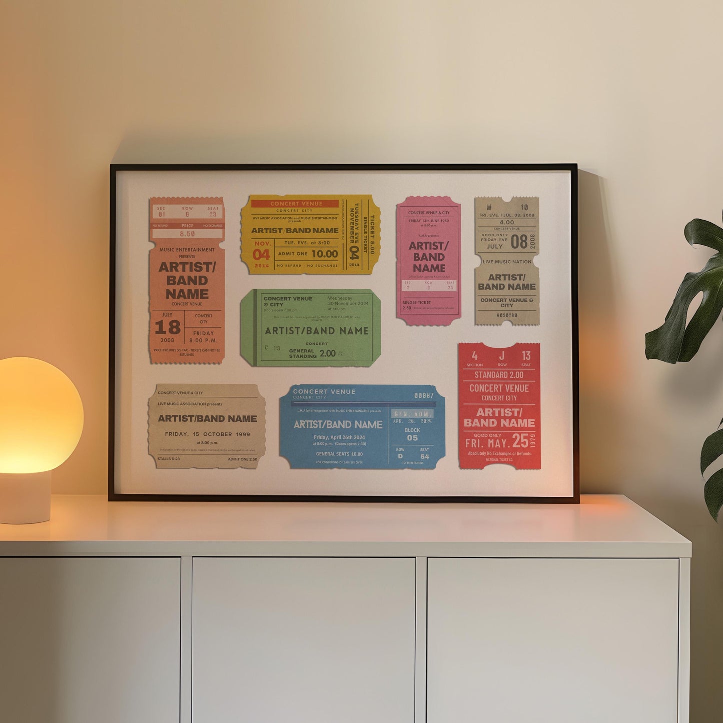 A warm lamp and white cabinet in a family home office. A large horizontal poster is on the counter near a plant showing worn edge and old faded ticket stubs inspired by old event keepsakes.