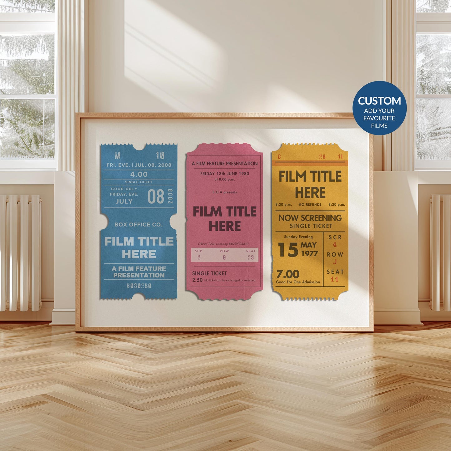 A modern home with wood floors and white walls. A large print is leaning on the wall with colourful vintage cinema tickets on it
