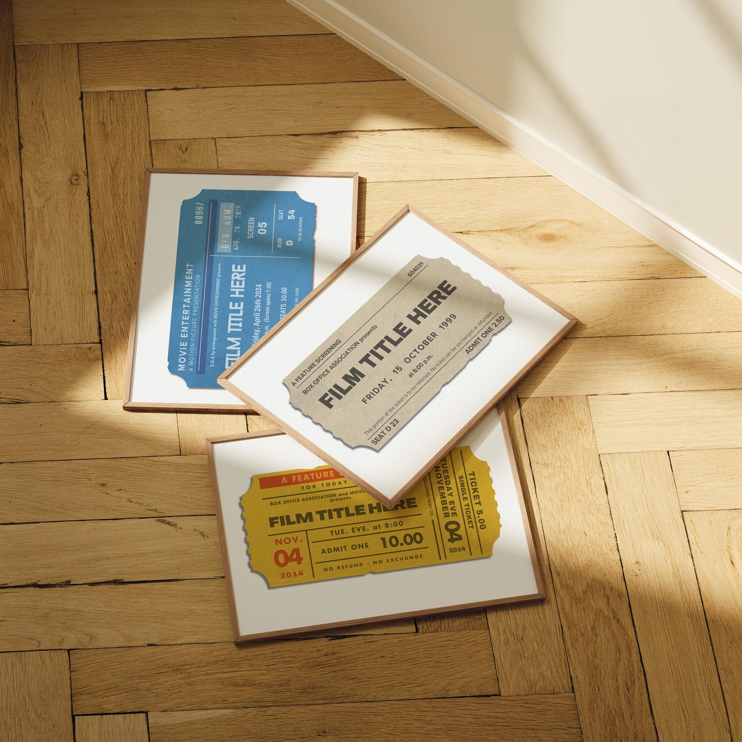 Set of three framed posters lid out on a traditional oak herringbone floor. The art is for live music events with a vintage inspiration from old cinema ticket stubs.