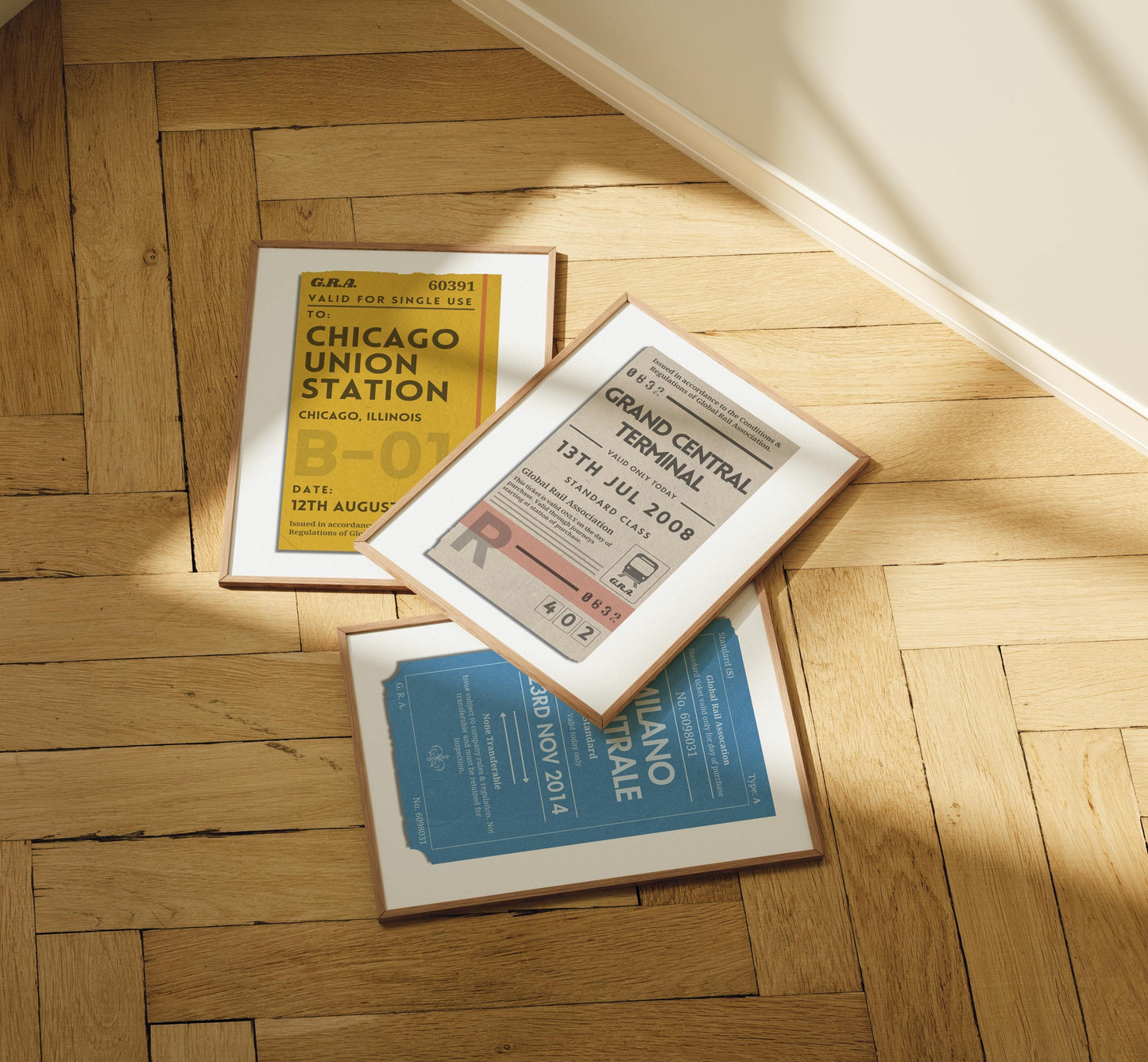 A set of three posters laid out on a wood herringbone floor. The art is vintage inspired ticket stubs for interrailing and train journeys.