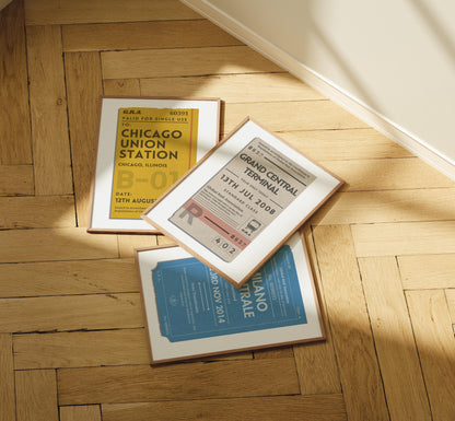 A set of three posters laid out on a wood herringbone floor. The art is vintage inspired ticket stubs for interrailing and train journeys.