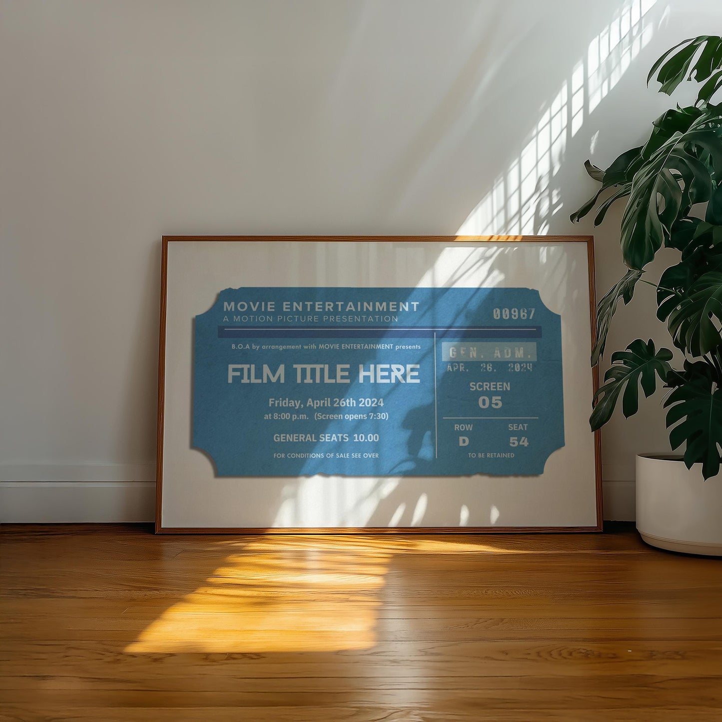 A well lit hallway with a poster leaning on the wall in a wood framing. The poster shows a designed old movie theatre stub with a bespoke film title on it.