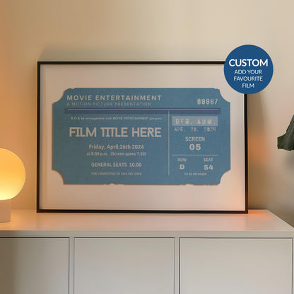 A cosy Livingroom with warm lighting and a large horizontal frame leaning on the wall. The art is minimalist and bespoke made inspired by old movie theatre tickets