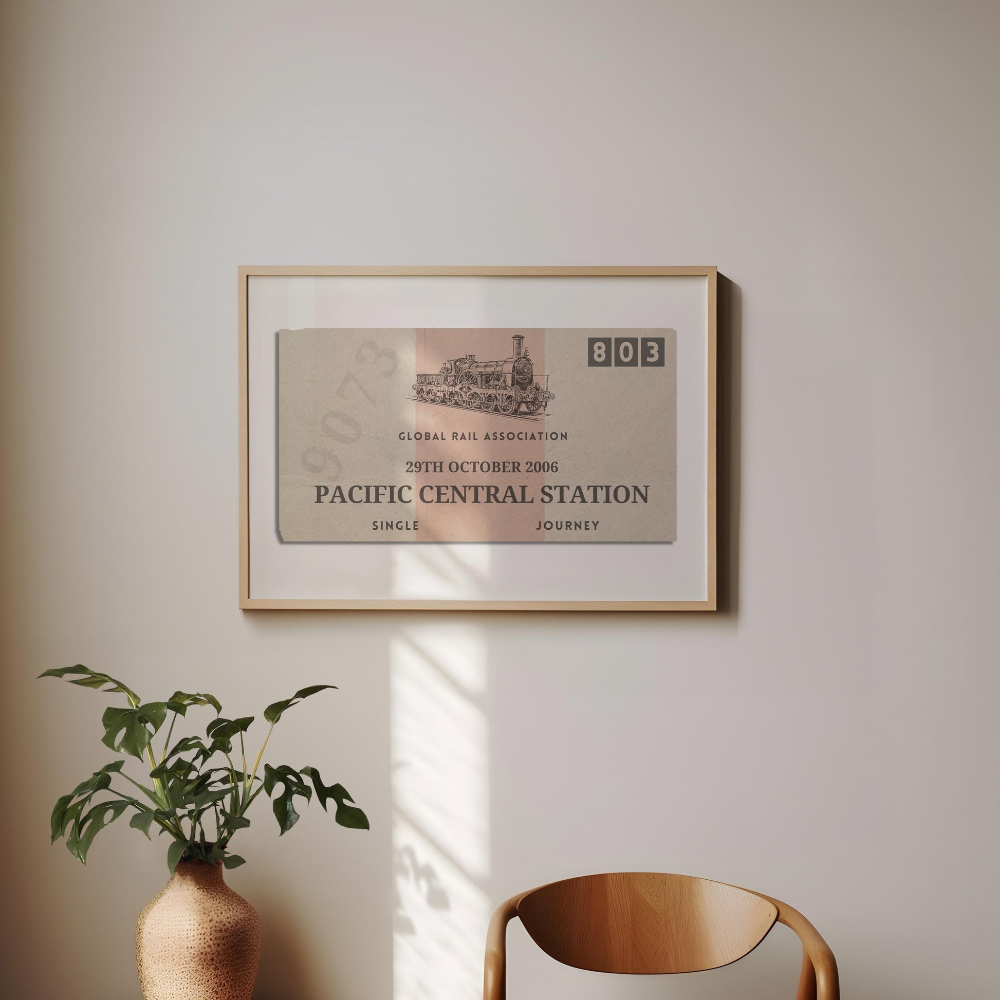 A minimal dining room with a wood curved chair and a plant. On the wall is a framed print of a personalised interrail luggage tag, inspired my old stubs to make a design for frequent travellers and holiday keepsake collectors