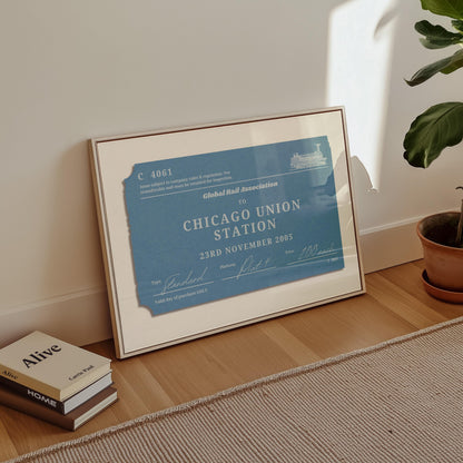 A minimalist apartment hallway with books and a poster on the floor. The print is a travel keepsake with a bespoke vintage rail luggage tag made as a trendy holiday memory décor piece.