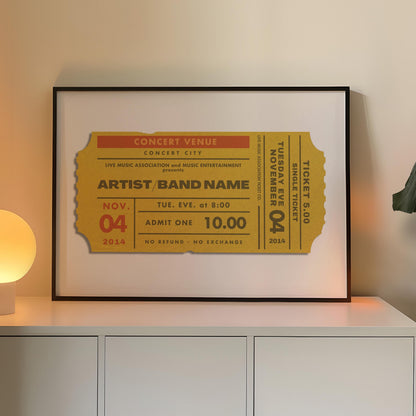A yellow coloured concert ticket design on a poster in a black frame in a warm lit office space. The art is personalised and has custom text details.