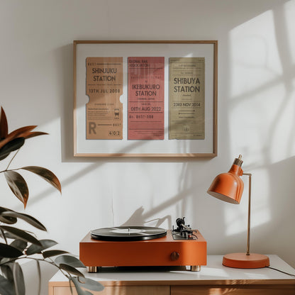 A orange lamp and vinyl player on a counter. A horizontal print is hung above which displays a nostalgic personalised eurail ticket stub poster in bright colours wth rustic aged details.