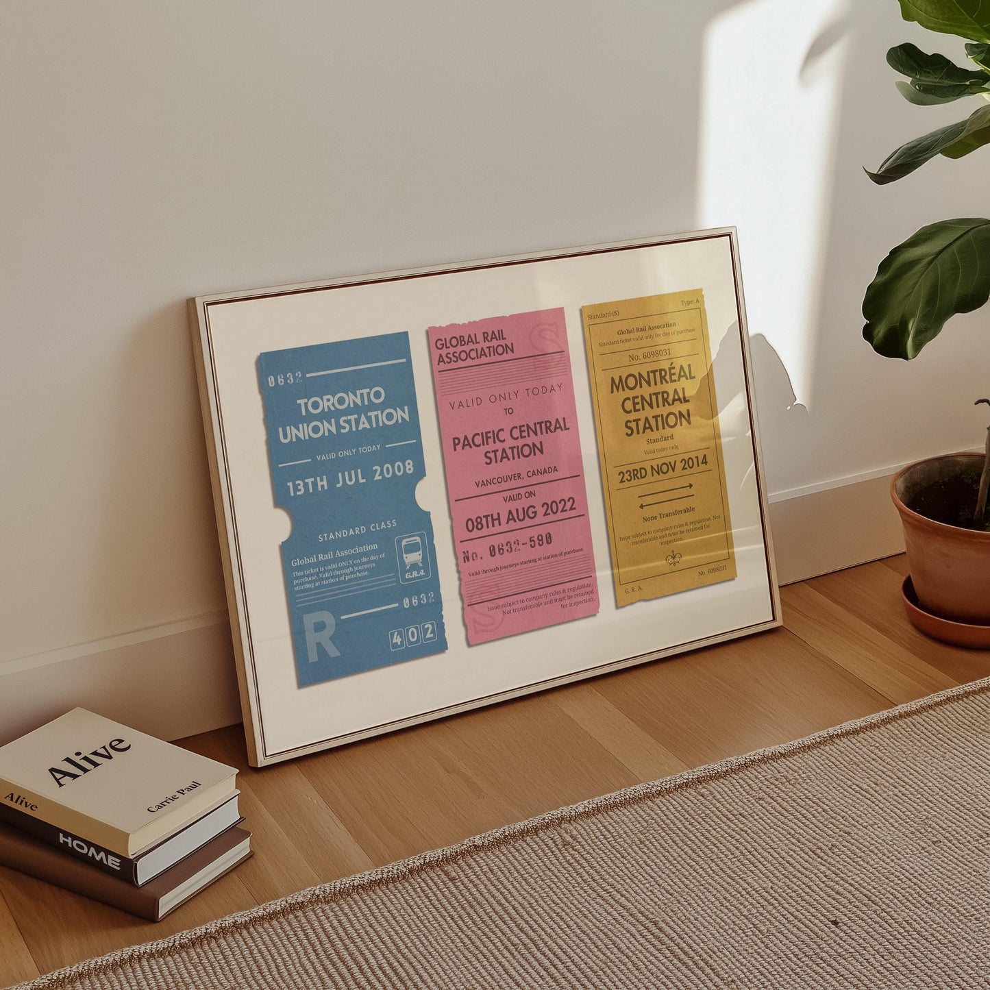 A minimalist apartment hallway with books and a poster on the floor. The print is a travel keepsake with bespoke vintage rail luggage tags made as a trendy holiday memory décor piece.