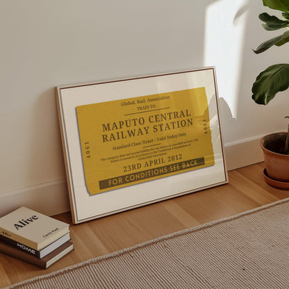 A minimalist apartment hallway with books and a poster on the floor. The print is a travel keepsake with a bespoke vintage rail luggage tag made as a trendy holiday memory décor piece.