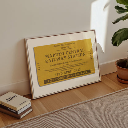 A minimalist apartment hallway with books and a poster on the floor. The print is a travel keepsake with a bespoke vintage rail luggage tag made as a trendy holiday memory décor piece.