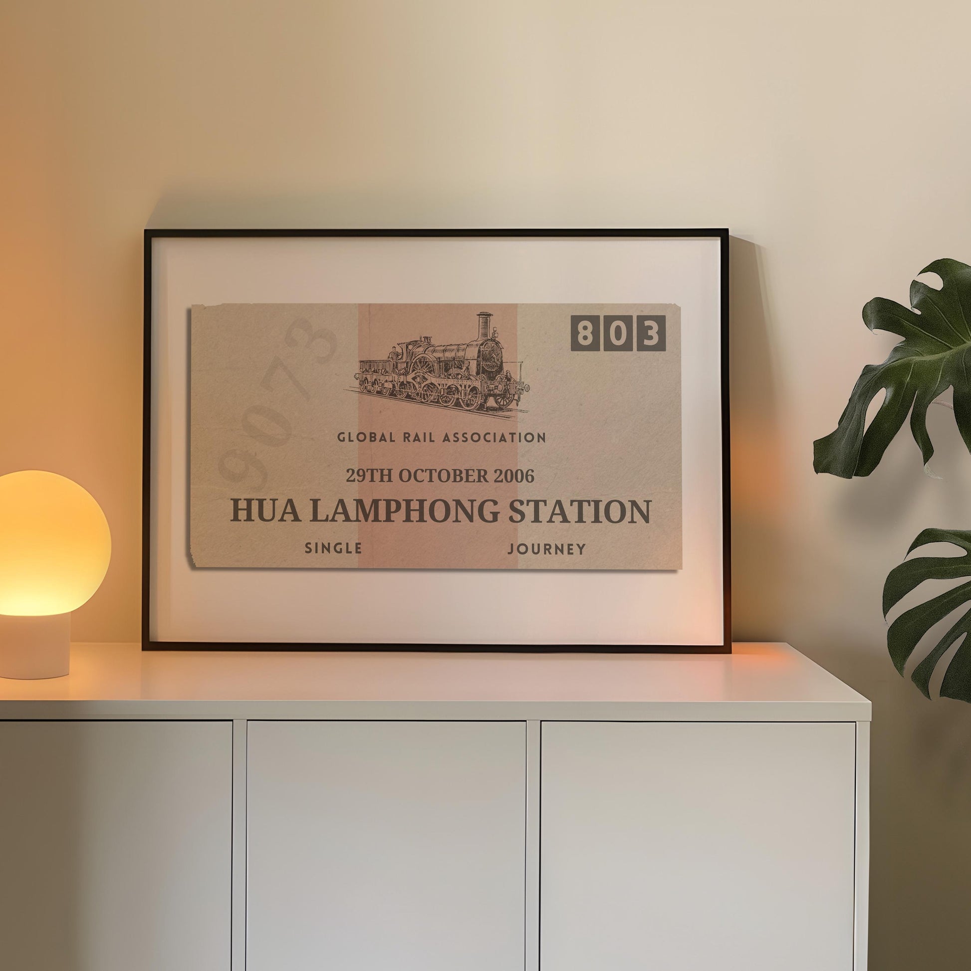 A cosy bedroom with a white sideboard. A poster is on top leaning on the wall which is a one of a kind railway stub artwork made for travel lovers as a keepsake for rail journeys and holidays.